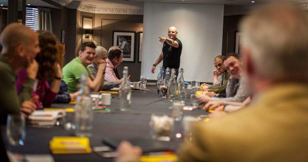 Brad Burton leading a small-group business workshop around a table