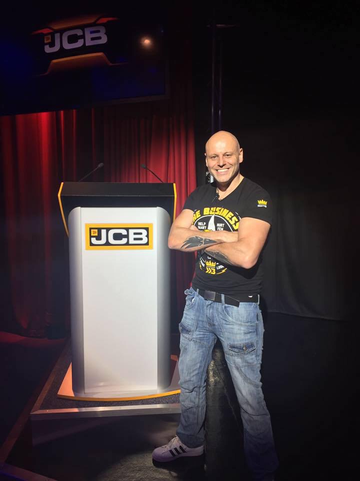 Brad Burton smiling beside a JCB lectern