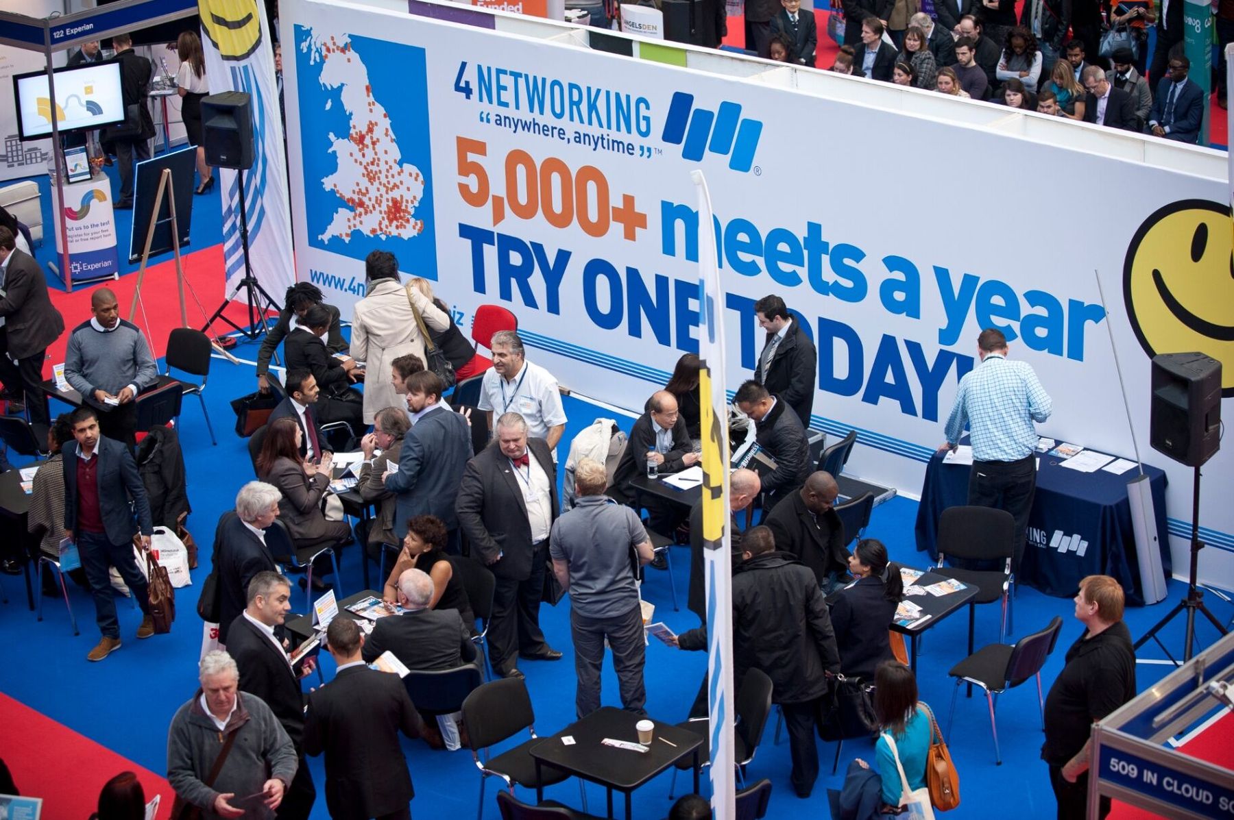 Crowded 4Networking exhibition stand with the wall slogan '5,000+ meets a year - try one today'