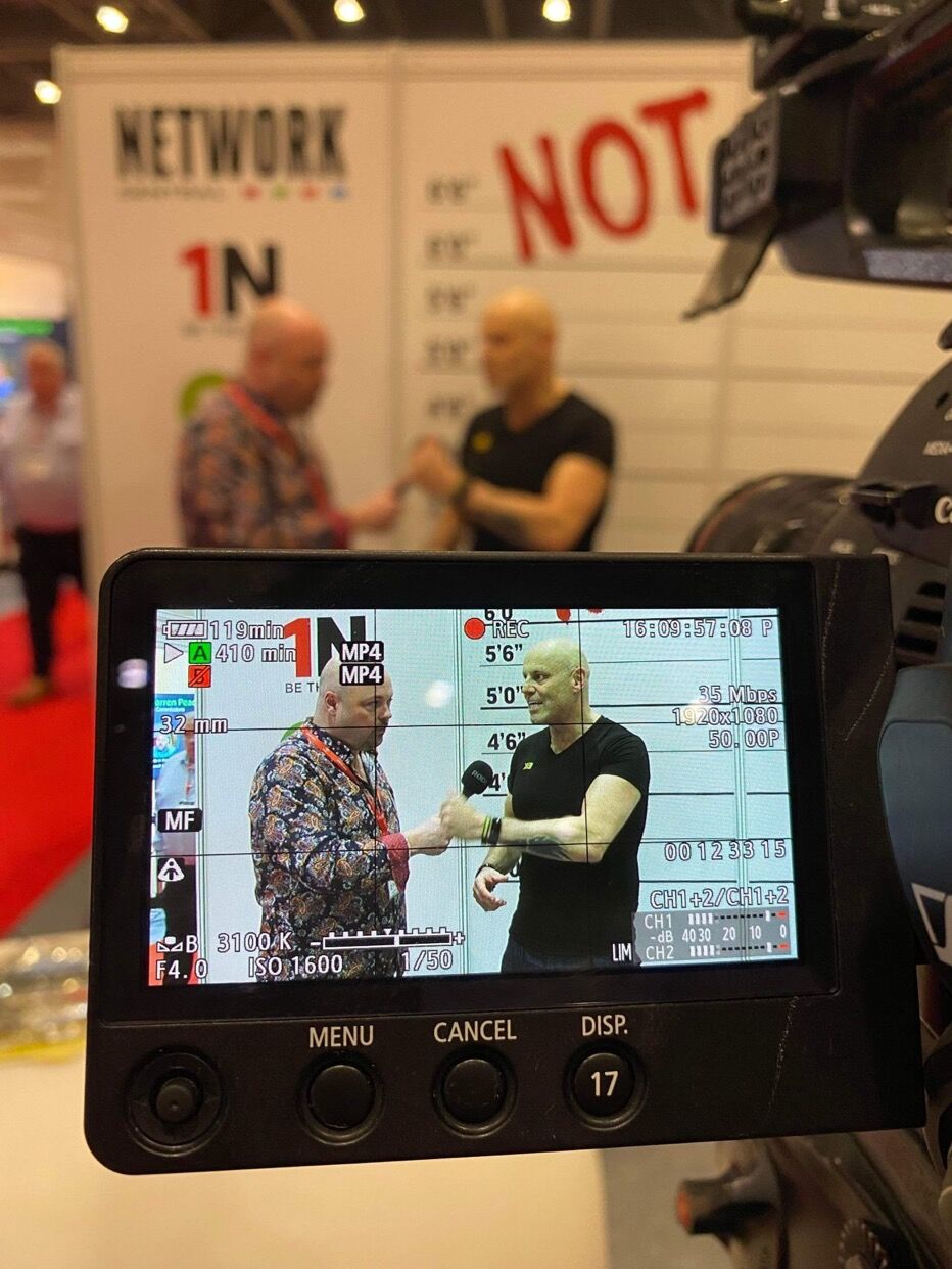Brad Burton being interviewed on camera at The Business Show on the 4Networking 'be the not·work' stand, viewed through the camera operator's monitor