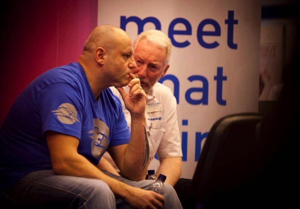Brad in an intense one-to-one conversation with a member at a 4Networking 'meet · chat · join' backdrop