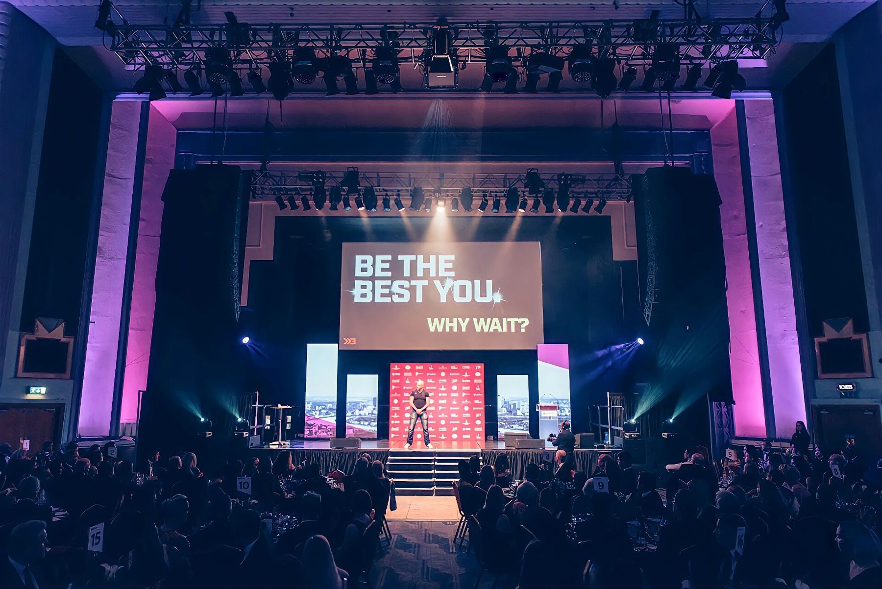 Brad on a fully lit main stage delivering a 'Be the best you' keynote