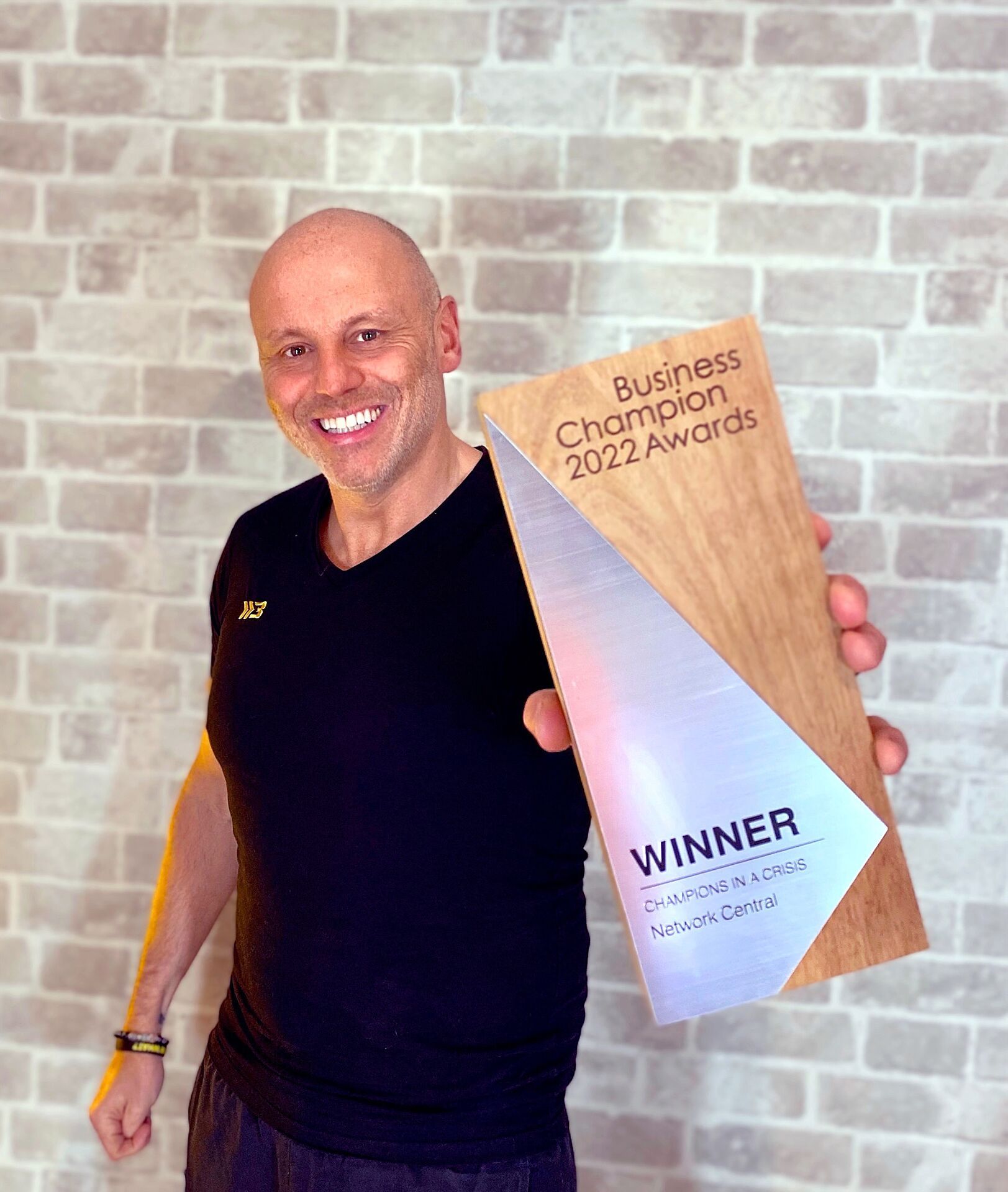 Brad Burton holding the Business Champion 2022 'Champions in a Crisis' winner award