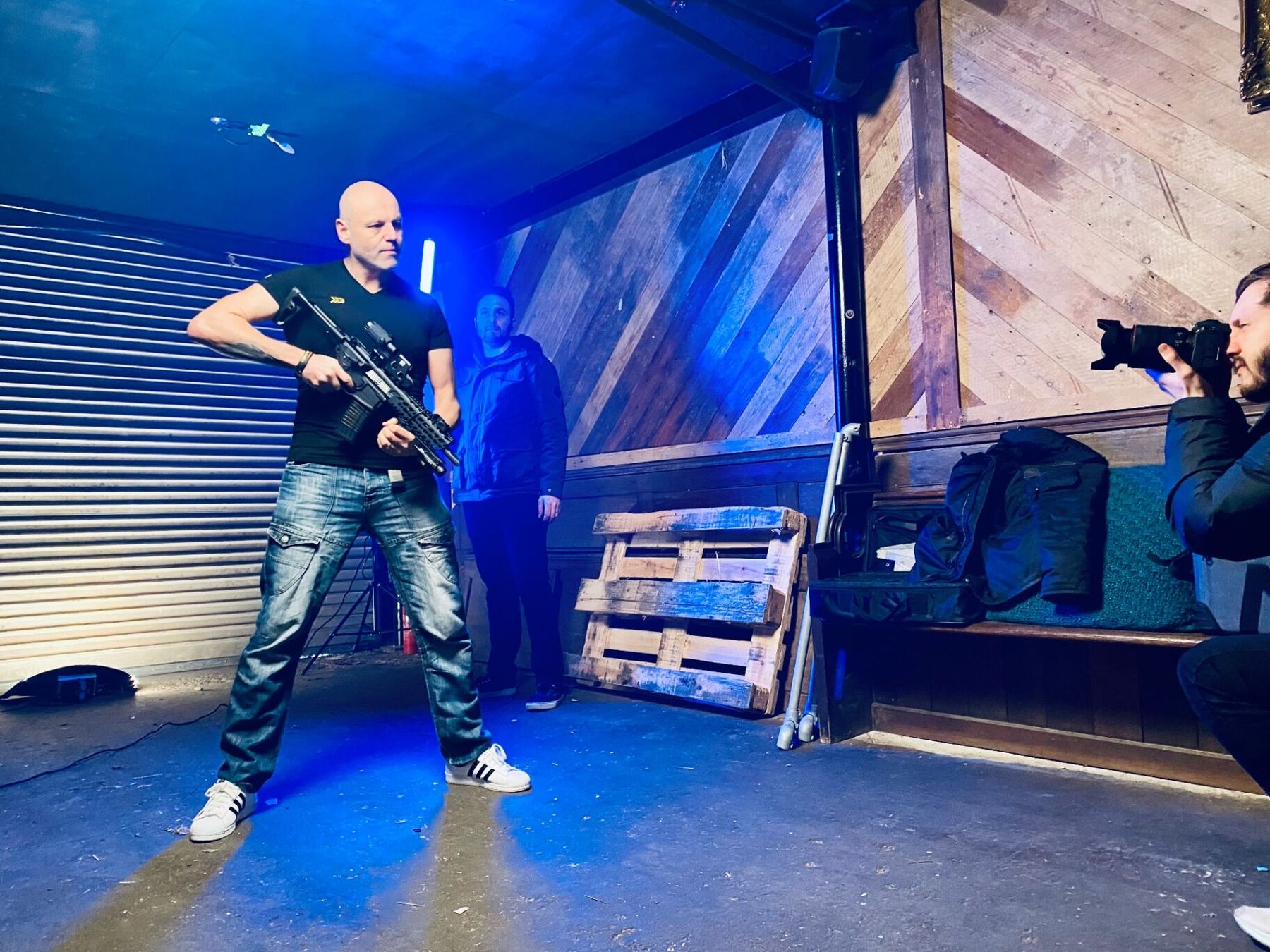 Brad Burton on a moody blue-lit brand shoot, photographer working the angle on the right of frame