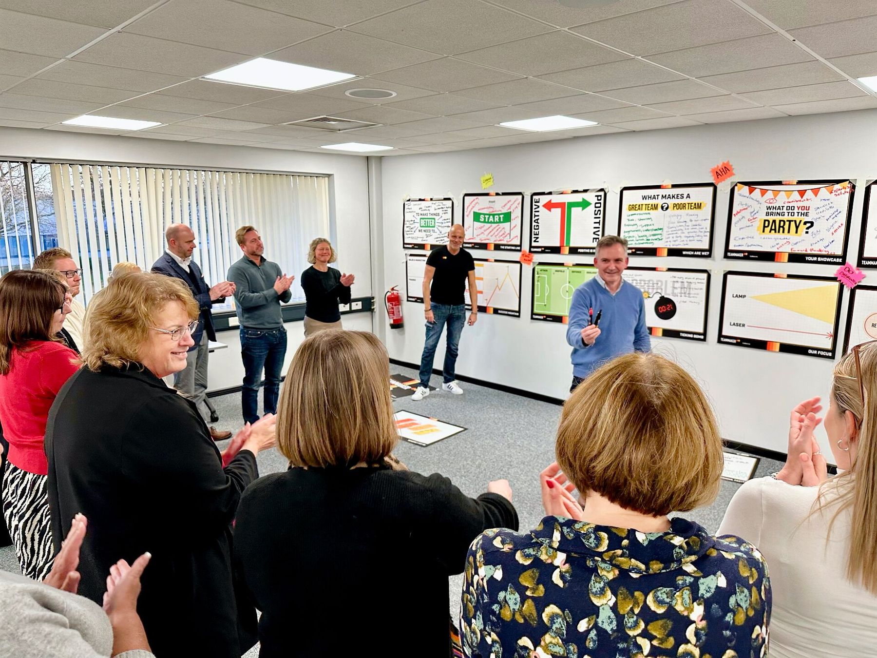 A Teammaker workshop room mid-applause as a delegate presents back to the group, Brad smiling on the side